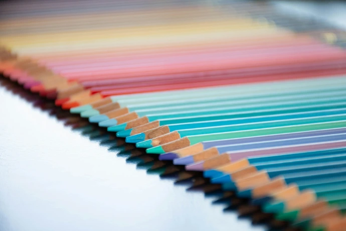 a row of colored pencils sitting on top of a table